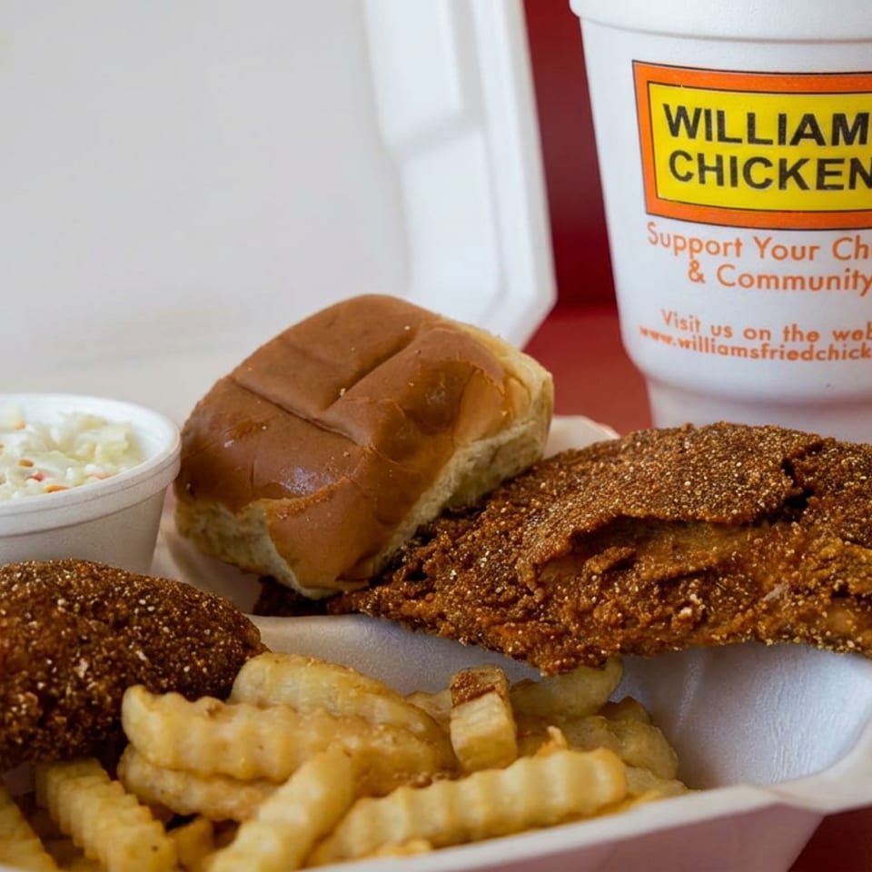 Williams Chicken meal with fried chicken, crinkle-cut fries, coleslaw, a bun, and branded drink cup in a takeout container.