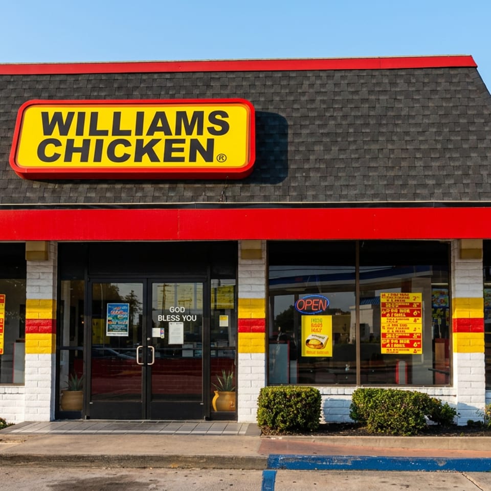 Williams Chicken restaurant exterior with red, yellow, and black signage, storefront windows, entrance, menu posters, and trimmed shrubs.